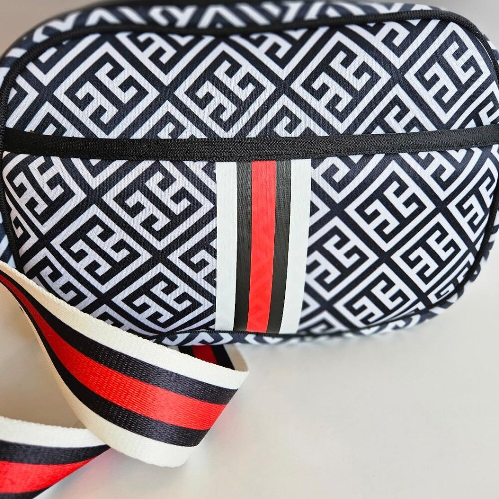 Black/white/red geometric pattern crossbody bag; adjustable/removable strap.